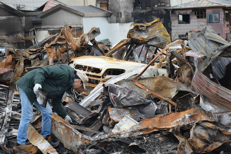 Чоловік шукає пам'ятні речі на попелищі свого будинку після великої пожежі в місті Ітоїґава префектури Ніїгата, 26 грудня (фотографія надана Jiji Press)